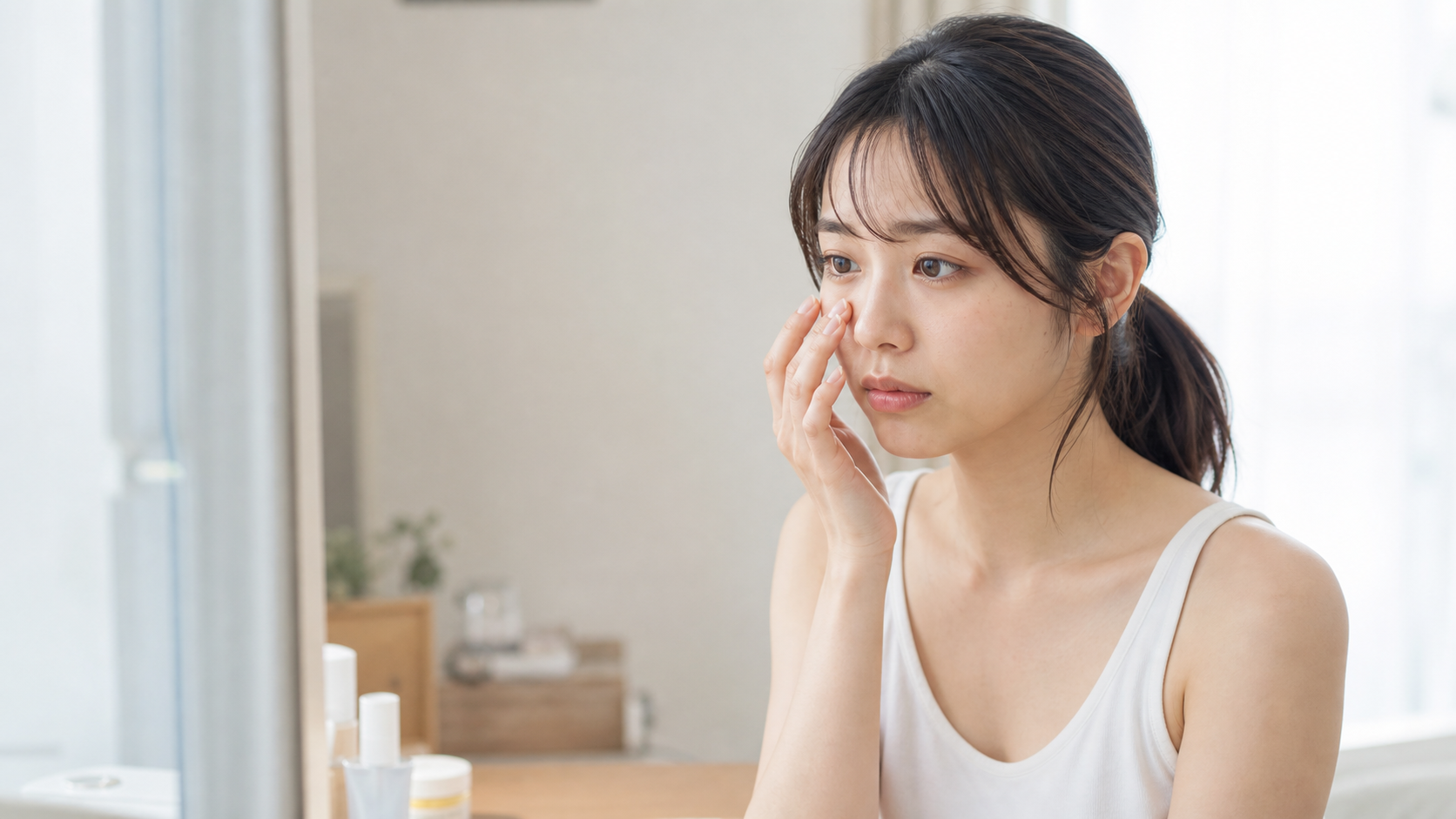 朝の身支度前に頬や小鼻まわりの肌状態を確認する女性